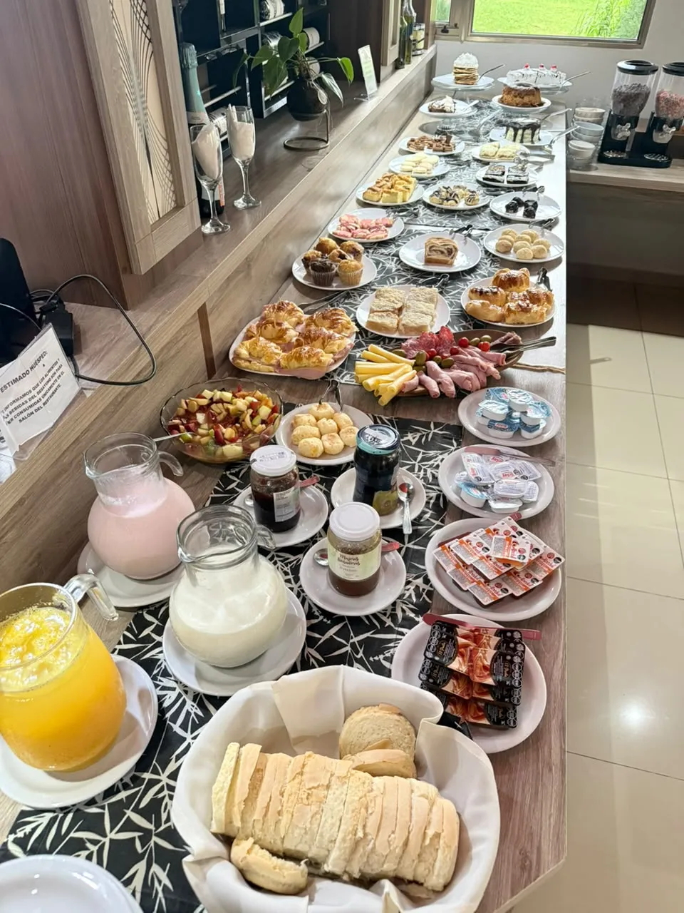Desayuno buffet con medialunas, tortas y sándwiches