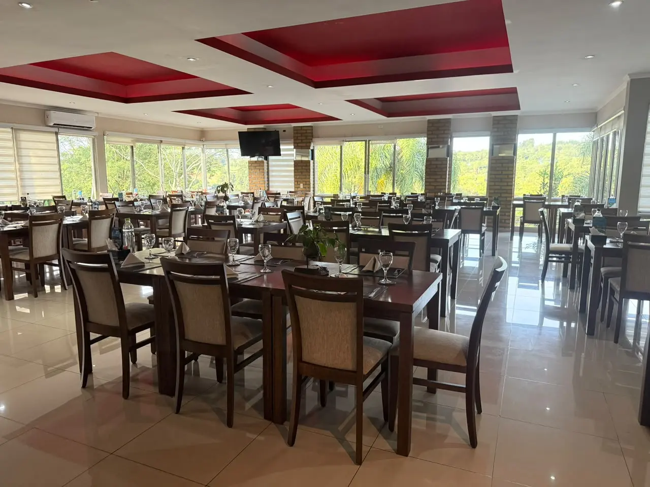 Salón del restaurante con techo rojo y ventanales